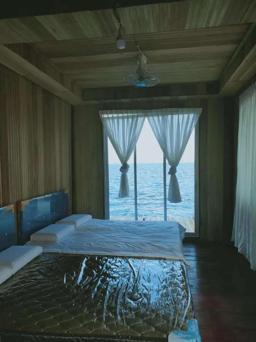 Double Bedroom interior at Egang Egang Resort showing comfortable beds and sliding glass doors looking out over the sea.